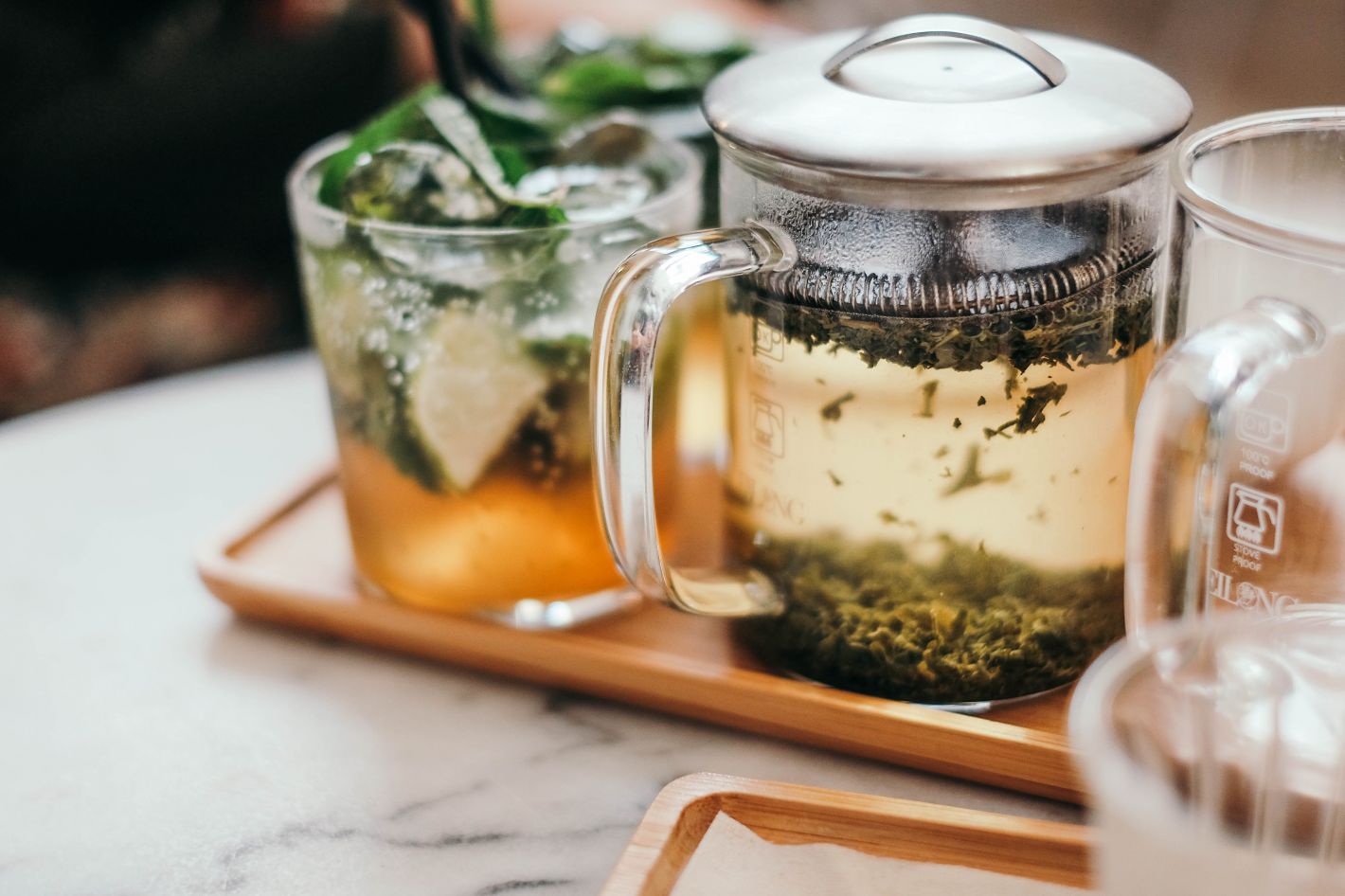 losse thee met kruiden in theeglas en theepot