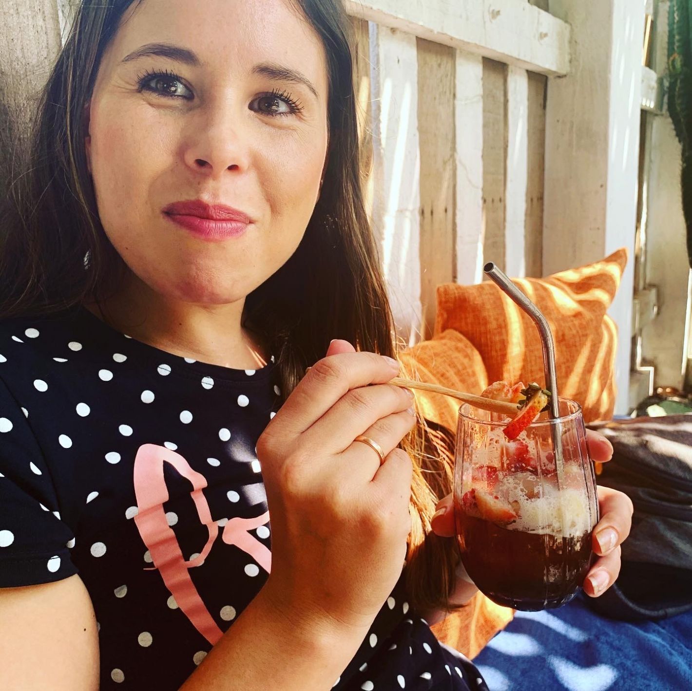 Kelly van Velthoven op een bankje een glas ijskoffie met aardbei en ananasfruit drinkt