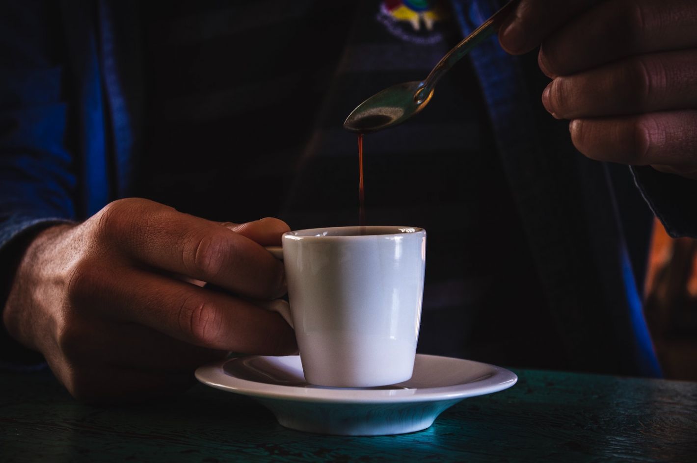 persoon lepelt in koffie kopje met espresso