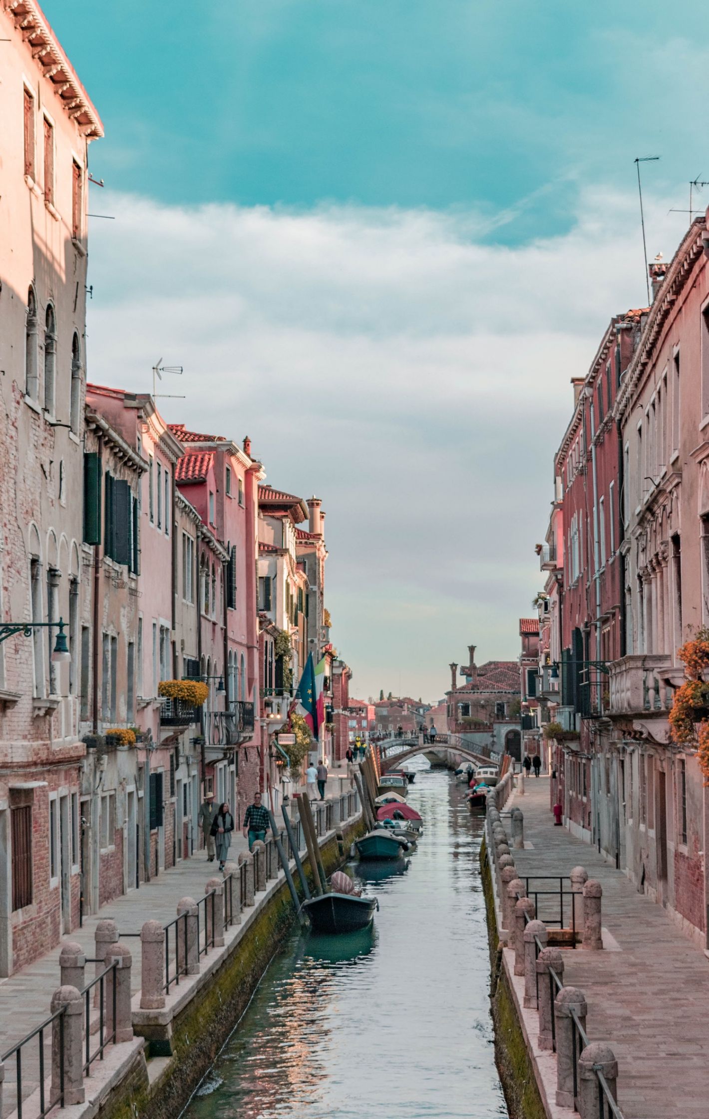 Roze huisjes in smalle straat in Italië met gracht