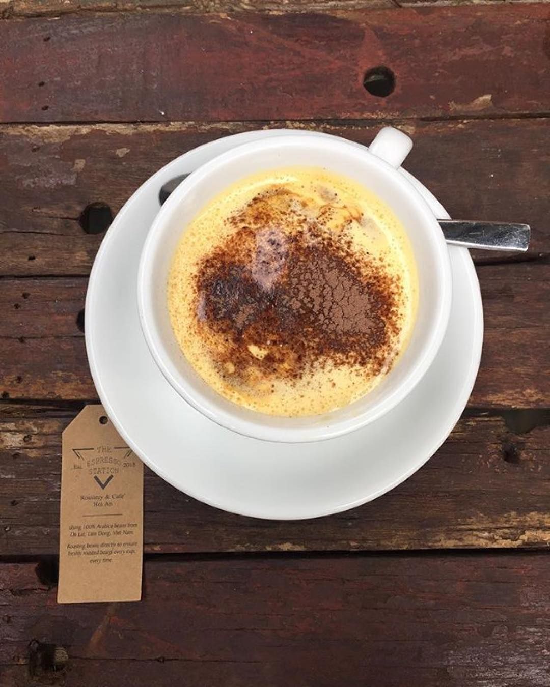 kopje egg coffee met cacao van bovenaf gefotografeerd op houten tafel van Espresso Station Hoi An