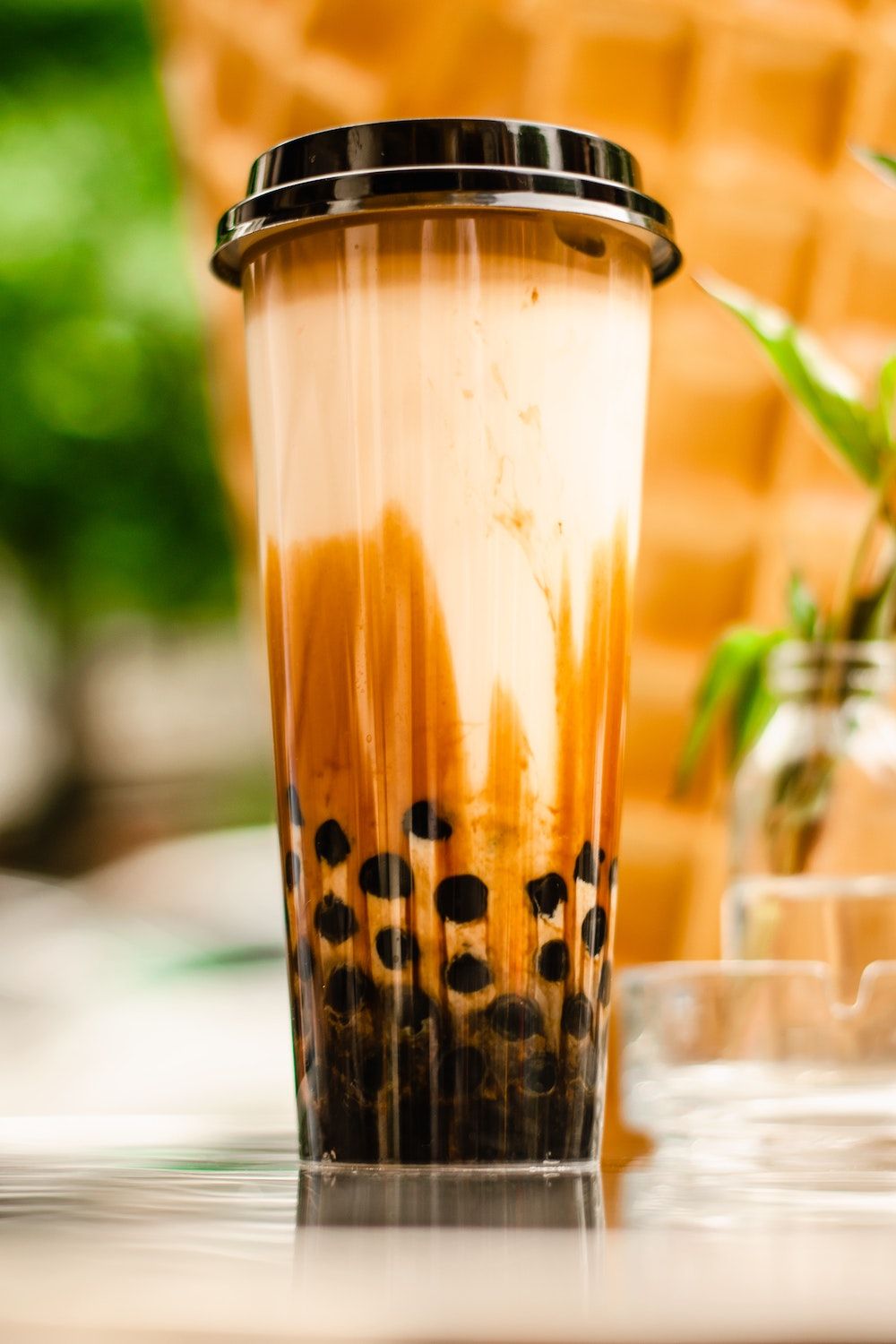 Lange plastic beker gevuld met bubble tea zwarte tapioca balletjes