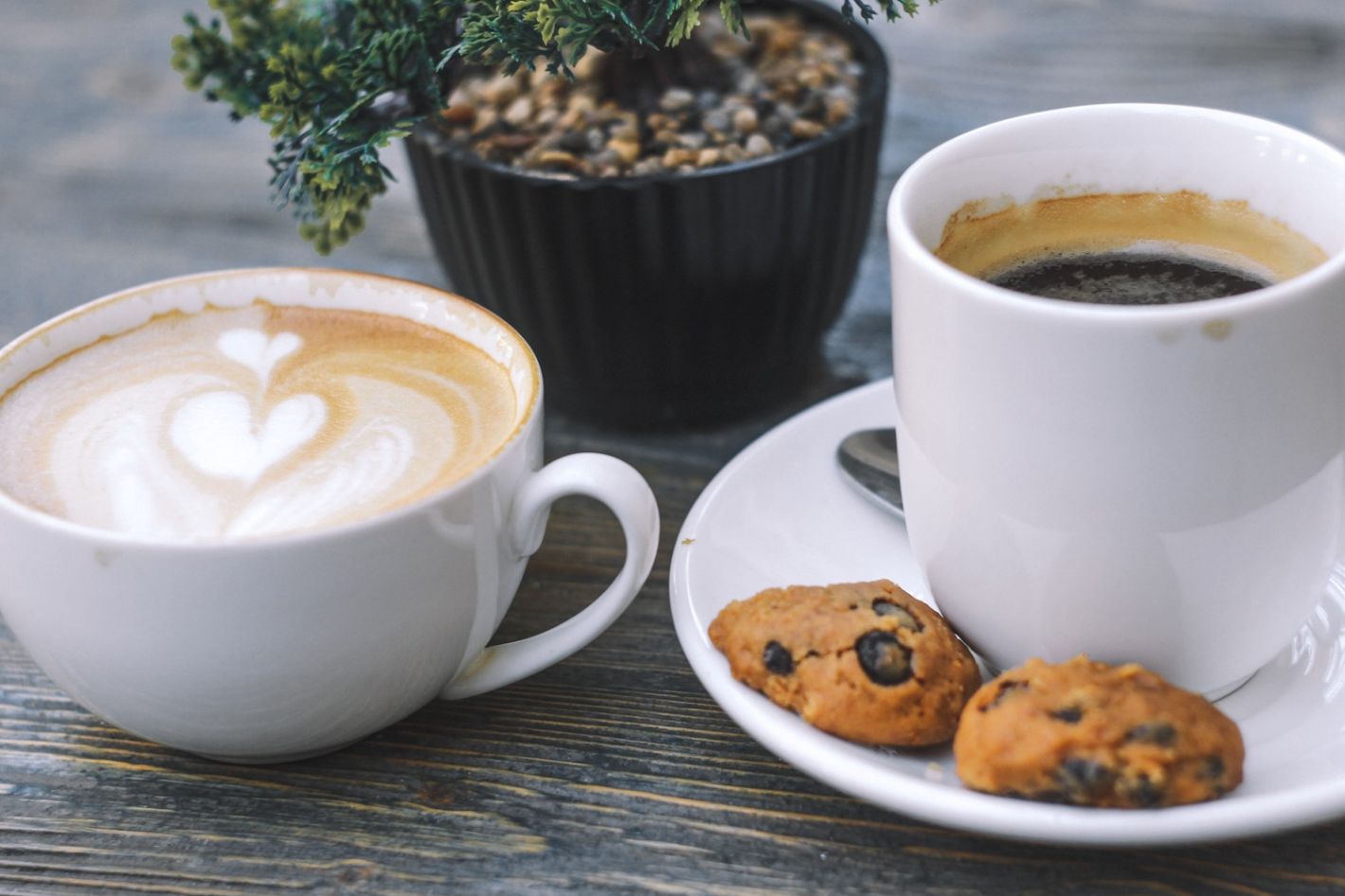 cappuccino en americano koffie op houten tafel geserveerd met koekjes