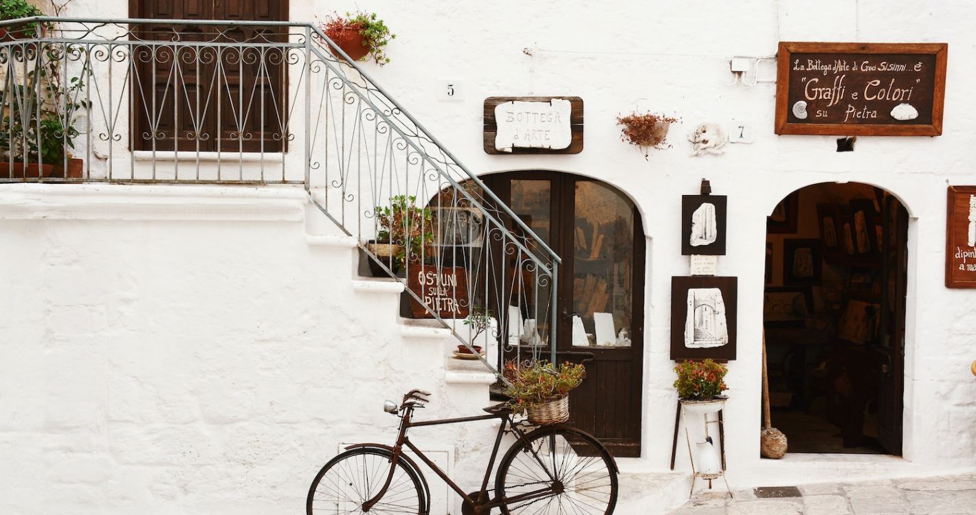 wit geschilderd Italiaans dorpje fiets voor trap met hek