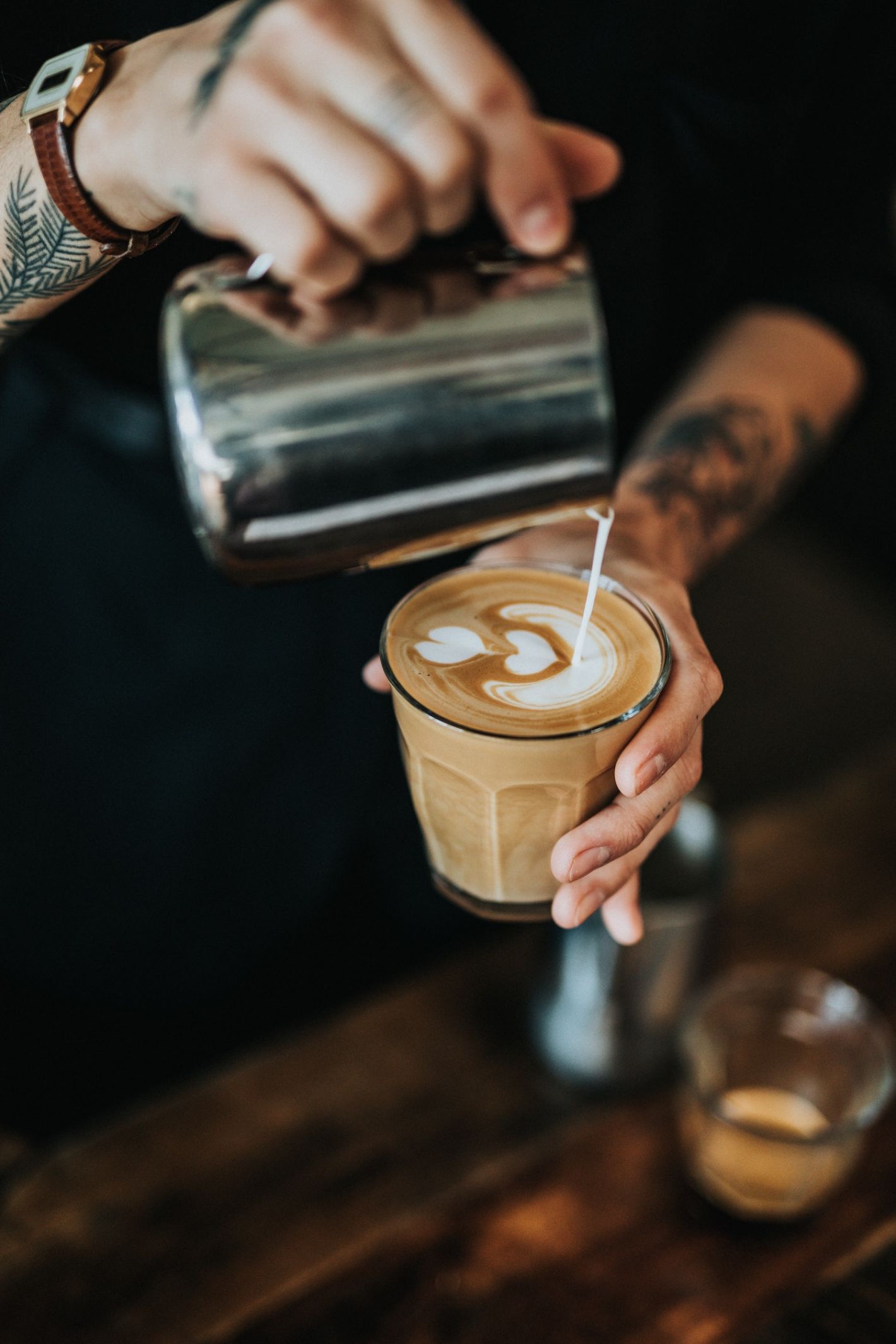 hand die melk schenkt op latte macchiato 