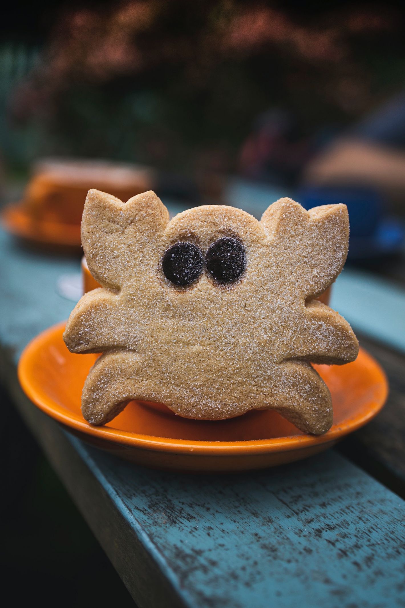 gingerbread koekje in de vorm van een krab met oogjes op oranje schoteltje