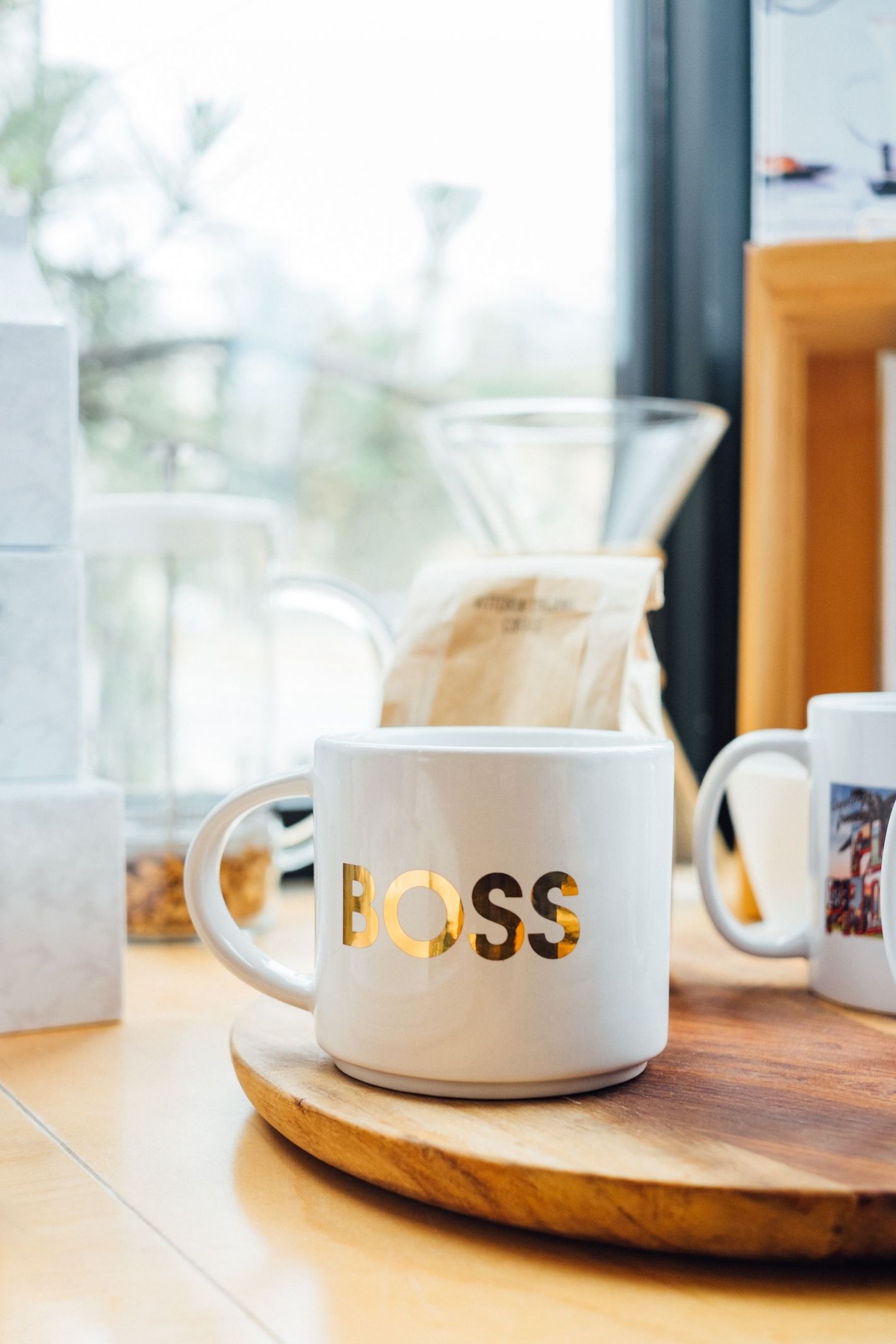 kopje met gouden letters boss op een houten snijplank