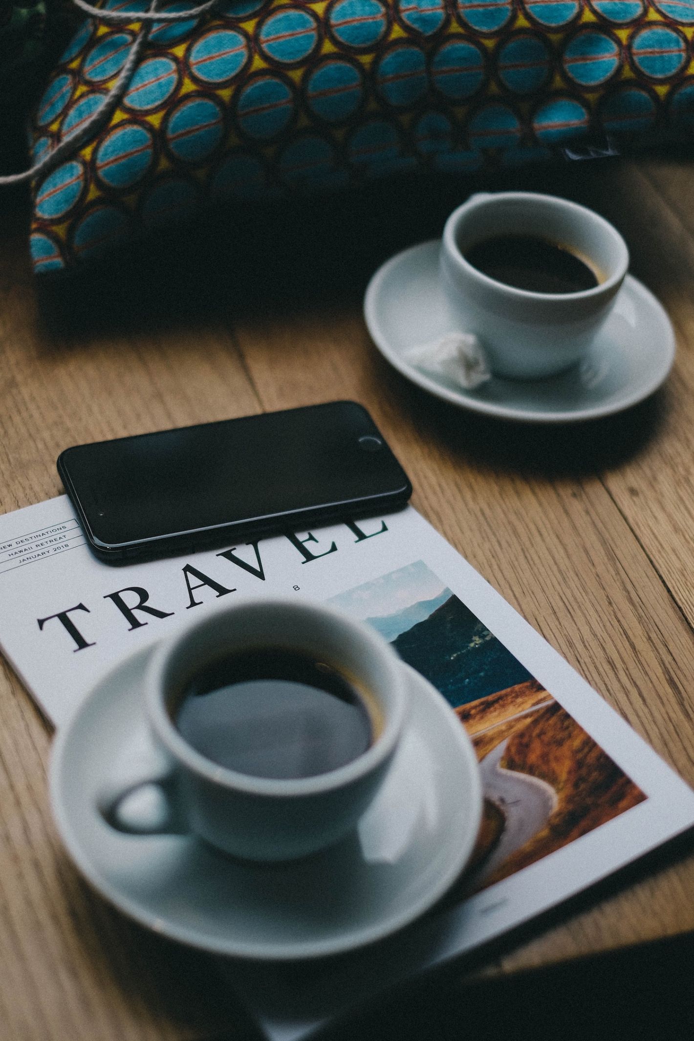 twee espresso's in witte kopjes met travel magazine op de ondergrond