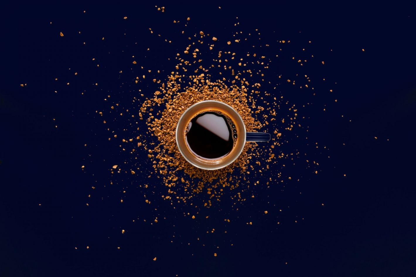 kopje espresso op zwarte ondergrond en gemalen koffie